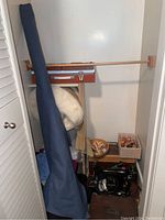 Closet view showing blue fabric bolt, white batting, trays and sewing machine below