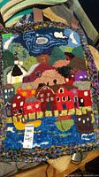 Colorful hooked wall rug with houses, barns, hills, sky in wool