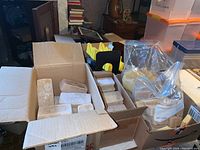 Three boxes of wax blocks and a plastic bag of wax chunks on a work surface