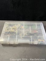 Closed clear plastic organizer box with visible internal compartments and some contents.