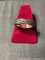 Front view of men's silver rope style ring displayed on red ring holder.