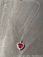 Full view of the heart shaped pendant necklace with chain displayed on gray background, showing the full necklace and pendant.