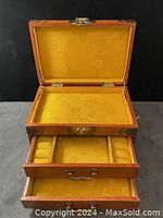 Front view of the jewelry box open showing the felt-lined compartments and rings slots inside the drawers.