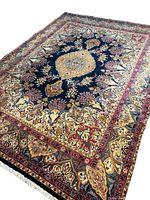 Angled full view of navy field rug with central medallion and multi-layered borders