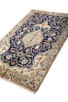 Full view of the Persian Naeen rug showing dark blue central field with cream border featuring floral and medallion patterns.