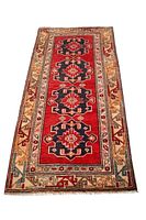 Full view of the red Persian runner rug with black medallions and beige floral border.