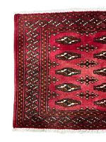 Detailed close-up of the corner of the Turkmen rug showing intricate border pattern and natural wool fibers.