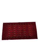 Full view of the rectangular Turkmen backrest rug with rich deep red background and repeating geometric guls motifs.