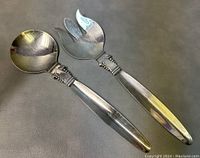 Two piece salad serving set by Viking Plate showing salad spoon and fork side by side on dark surface