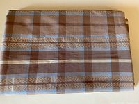Photo showing folded silk fabric with visible pale tea, blue and milk chocolate check pattern