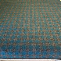 Close view of speckled turquoise and grey check wool fabric showing overall pattern and texture.