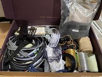 Large container with assorted costume supplies including trims, strings, lace, and shoulder pads