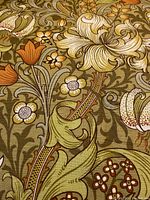 Close-up view of fabric pattern showing floral design in olive-green, cream and rust colors.