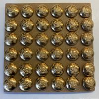 Top view showing 36 brass buttons mounted on original card in 6 rows of 6.