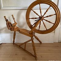 Full view of the handcrafted vintage solid wood spinning wheel constructed from maple wood, showing the large wheel and turning spindle mechanism.