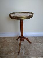 Full view of the antique side table showing the round marble top with brass gallery, cherry wood pedestal, and tripod base.