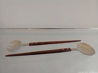 Salad servers laid flat showing full length and material details