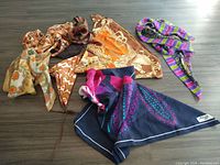 Seven assorted vintage scarves displayed flat to show color and pattern variety.