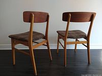 Rear view of both chairs showing teak backrests and beech frames