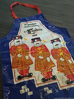 Front view of kitchen apron showing colorful Beefeaters design and 1988 London text.