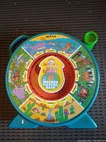 Full view of the circular Mattel Mother Nature Says talking See and Say toy showing the nature and animal scenes in color.