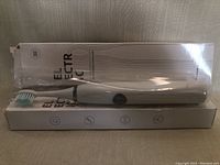 First toothbrush out of the box with box visible behind showing packaging and part of the product