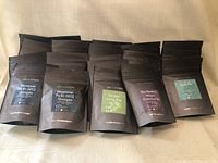 Multiple packets of black matte resealable pouches with labels from Pur & Simple laid out in rows showing assortment.