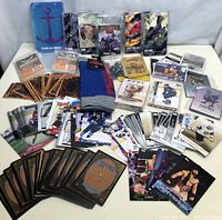 Full view of all collector cards laid out including summoner wars packs, sports cards, card sleeves and Zelda socks.