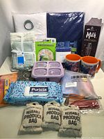 Lot contents showing assortment of kitchenware items including reusable produce bags, disinfecting wipes, mugs, food containers, towels, and frother box