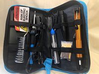 Opened soldering iron kit showing all tools and accessories organized inside the case.