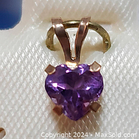 Close-up front view of the 10K yellow gold heart-shaped amethyst pendant showing the faceted purple gemstone and gold prong setting.