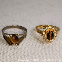 Two vintage cat's eye rings, one silver tone with simple setting, and one gold tone with rhinestone halo