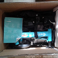 Boxed Elenker knee scooter showing teal frame and instruction manual inside.