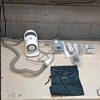 Full set of Neabot pet grooming vacuum device with clear flexible hose and multiple grooming attachment heads wrapped in plastic.