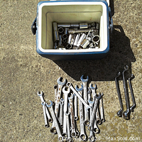 Overall view of the lunch box open with sockets inside and wrenches and combination wrenches laid out next to it showing sizes and wear.