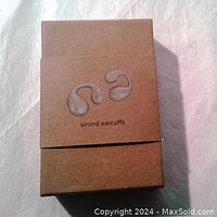 Closed packaging box for the Sound Earcuffs wireless earbuds with logo printed.
