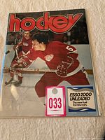 Front cover of the 1974 NHL hockey program showing a player in a Detroit Red Wings uniform with 'hockey' title and advertising labels attached.