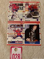 Four Patrick Roy hockey cards laid out on a white textured surface, showcasing front images.