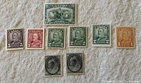 Photo showing ten old Canadian postage stamps of various denominations and designs on a light textured background