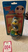 Full view of the Donald Duck bobblehead in original blister pack with cardboard backing showing wear and tear on package edges.