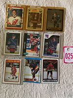 Display of all nine vintage hockey rookie cards on white fabric background, showing various players.