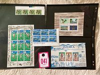 Overview of several sheets and blocks of vintage Jamaican mint stamps with a commemorative cover and auction tag 041