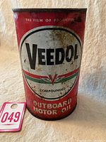 Front view of a red and white Veedol branded outboard motor oil can, showing the logo and product text.