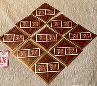 Nine brown and gold diamond-shaped souvenir sheets arranged in a pattern, each containing two tiger face stamps.