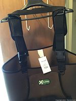 Hip waders hanging showing front with adjustable straps and brand patch