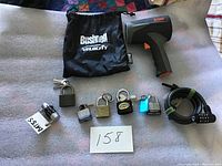 Overview of security package components including 6 locks, cable lock, and Bushnell Velocity speed radar device with drawstring pouch on fabric surface