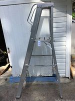 Front profile of silver 6-foot aluminum step ladder showing four steps and top platform