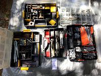 Five segmented plastic organizers containing assorted fasteners including nuts, bolts, lag bolts, turnbuckles, screws, washers in a black plastic storage bin.