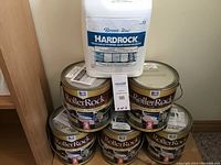 Stack of five Daich RollerRock paint cans with one Beauti-Tone Hardrock sealer pail and auction tag