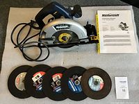 Mastercraft circular saw laid on cloth with 6 masonry cutting wheels and operating manual visible. Lot includes all items for sale, showing condition and contents.